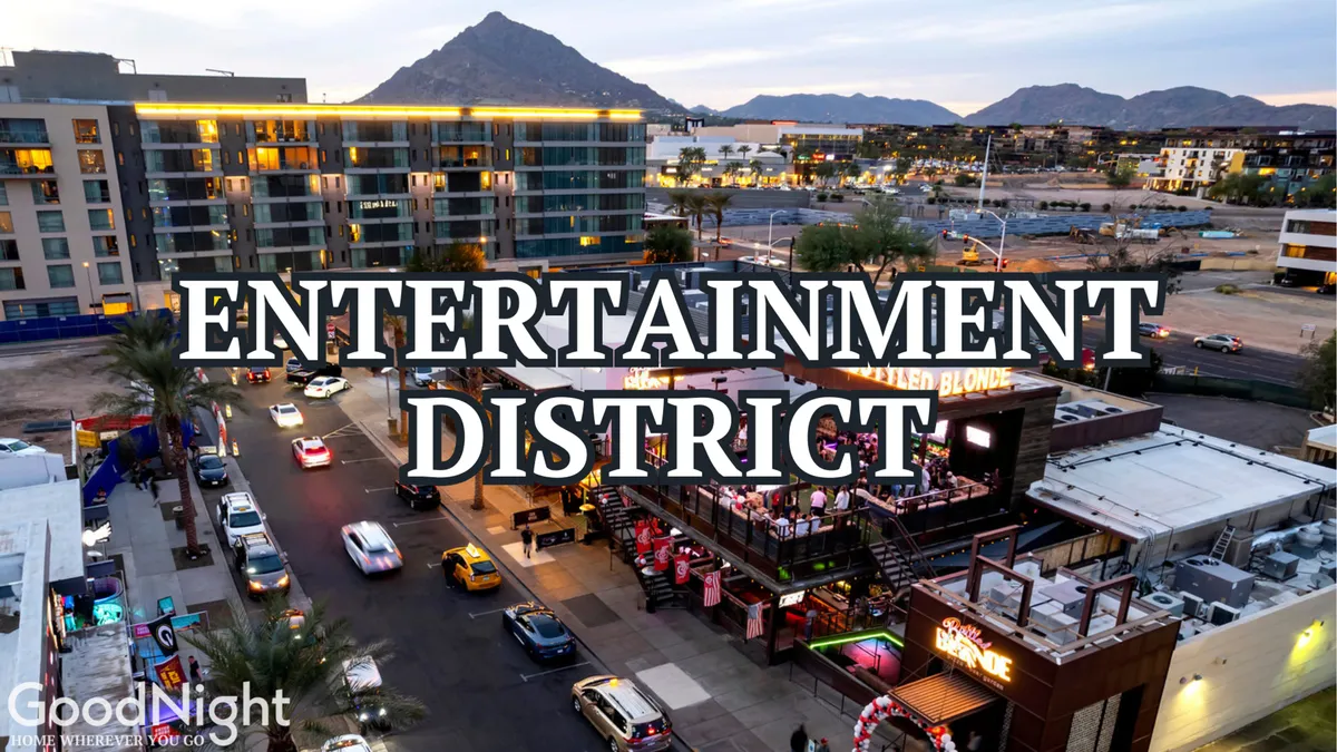 A vibrant scene from Scottsdale’s entertainment district, featuring prominent signage, an outdoor dining area bustling with activity, cars on the street, and the mountains in the background. The energy of nightlife and group outings is palpable.